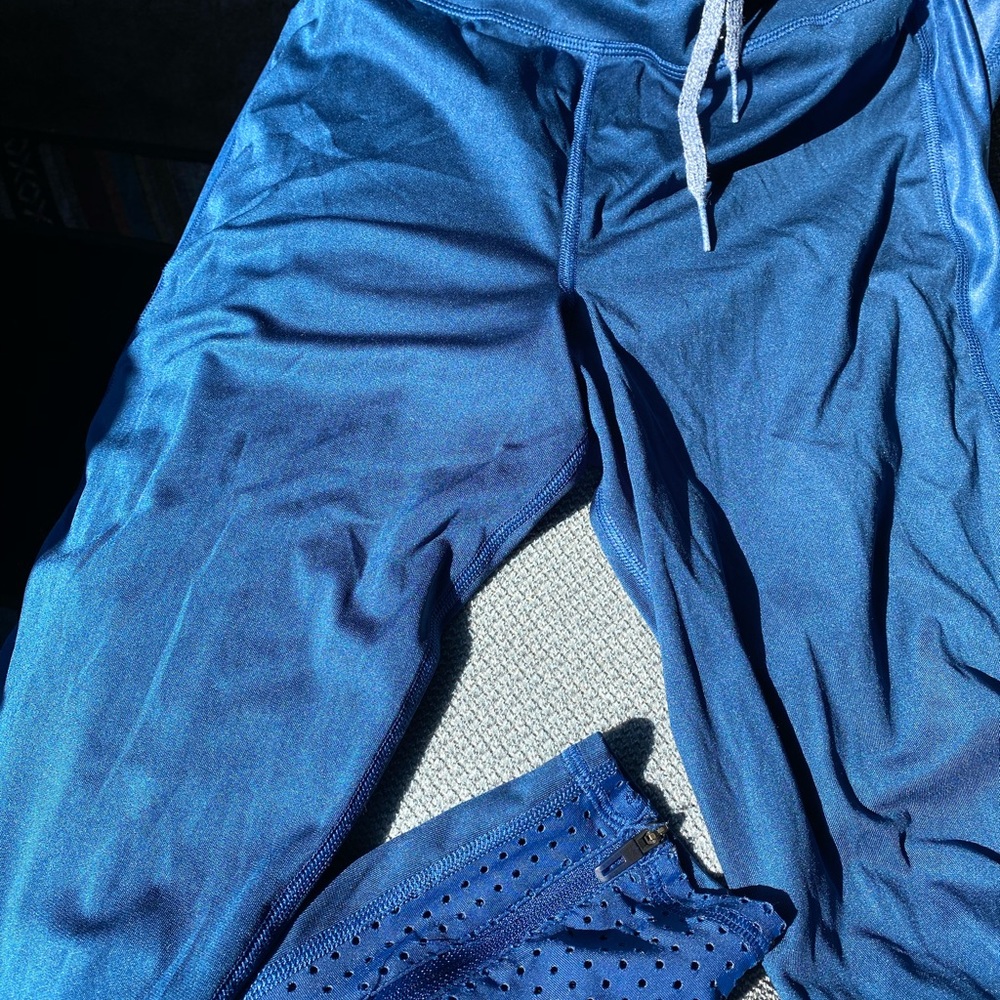 Adidas leggings with zipper and net at ankle.